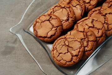 Crunchy homemade cookies on glass plate on gray background
