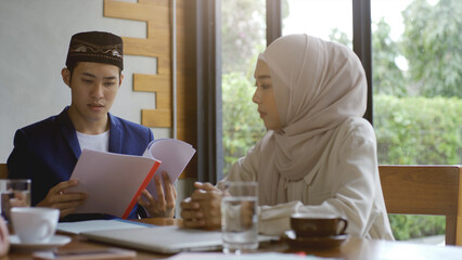 A group of successful upwardly mobile Asian Muslim friends relish a tranquil coffee shop gathering on a bright and joyful sunny day