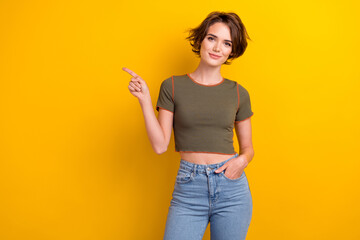 Portrait of gorgeous girl with short hairdo wear khaki t-shirt arm in pocket directing empty space...