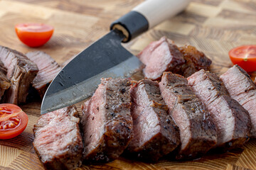 A steak on a cutting board with herbs and spices.Grilled beef tenderloin steak on a wooden board with grilled vegetables. Filet Mignon recipe concept, selective focus