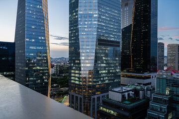 At sunset, lights are turned on on the glass windows of buildings in Yeouido, and the night view of the city is reflected in the windows.