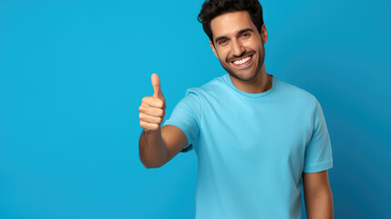 Young handsome man standing over isolated blue background doing happy thumbs up gesture with hand.