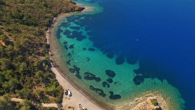 Aerial view beautiful cozy place for wild camping with cars and vans on coast of mediterranean sea in Turkey. van tourism summertime seaside travel vacation. secluded beach on island shore