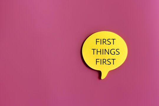 Top view image of speech bubble with text FIRST THINGS FIRST on pink background with copy space