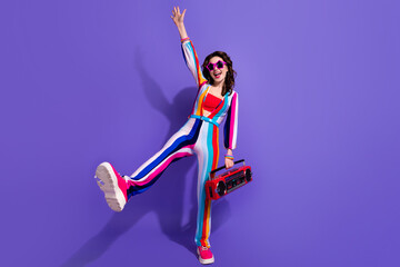 Photo of positive cool girl dancing active energetic with boom box pop music isolated on vivid...