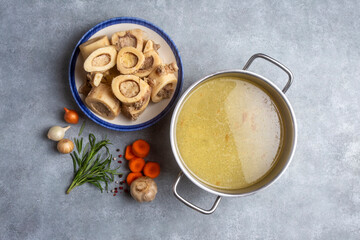 Boiled bone and broth. Homemade beef bone broth is cooked in a pot on. Bones contain collagen,...