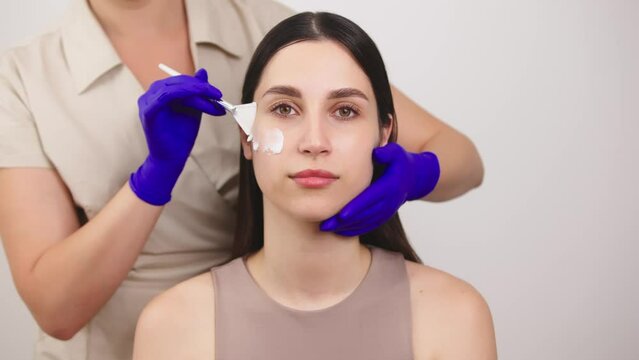 Slow motion portrait young woman uses creams of her face. Concept for fresh moisturized skin beautiful closeup cosmetic face happy healthy model. Young blonde hair woman take care of her skin.