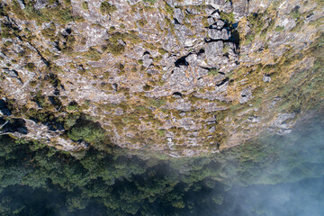 aerial top view of a mountain cliff on a foggy day
