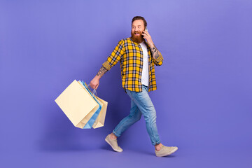 Full length photo of funny guy wear trendy clothes step store speak phone look back empty space...