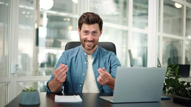 I know how to earn, happy smiling man having idea about big profit showing money gesture pointing to laptop, cash, body language. Male manager standing in office place looking at camera.