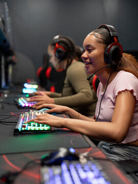 Female friends playing video games in gaming club © Cultura Creative
