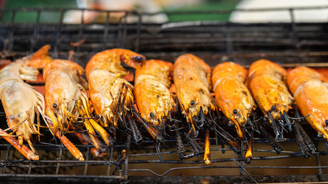 Big pieces of river prawn are gilling with flame over the stove, Seafood BBQ meal close-up photo. selective focus.