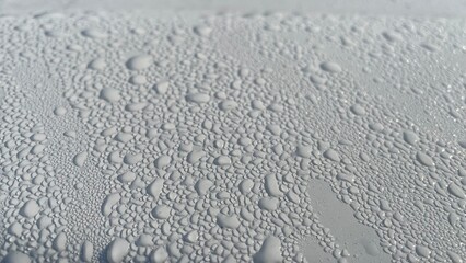 Dewdrops fall on the metal surface, creating a beautiful water bubble texture