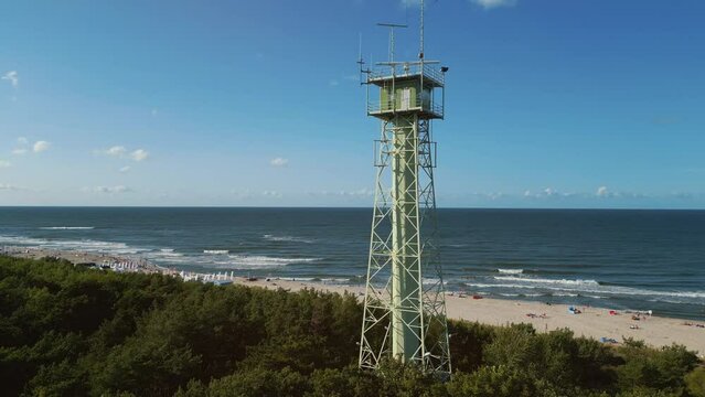 border observation tower with radar and antenna, sea shore with beach, 4k aerial