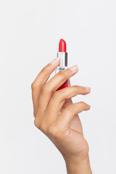 Studio shot of woman's hand holding red lipstick