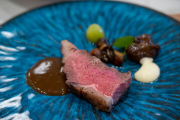 Medium rare meat served on plate with sauce