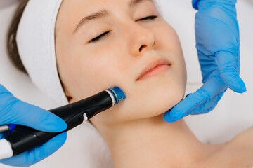 Facial skin care machine in spa clinic for anti-aging or acne treatment. The concept of aesthetic...