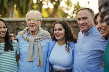 Naklejka premium Group of multi generational people hugging each other outdoor - Multiracial friendship and community concept