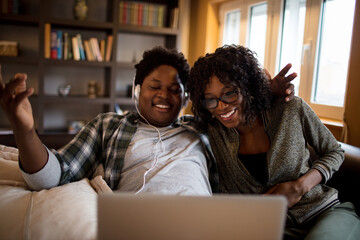 Young couple using a laptop together on the couch in the living room