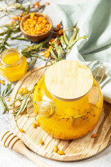 Healthy sea ​​​​buckthorn tea with honey on a gray stone background. Autumn tea, berries seasonal drink.