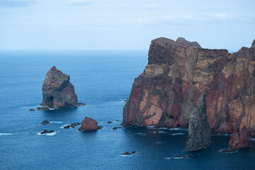 Fototapeta premium Massive orange cliffs and rocks at the Atlantic Ocean coast in madeira