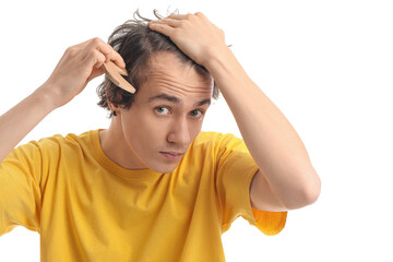 Young man combing hair on white background
