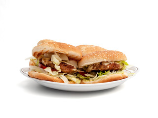 Homemade hamburger on a white background. Delicious burger with cheese, bacon, onion, cucumber, tomato and lettuce on a white background.