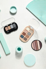 Palettes of eyeshadows with podiums on white background