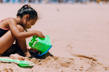 young girl playing in sand of beach on island of Tenerife Spain