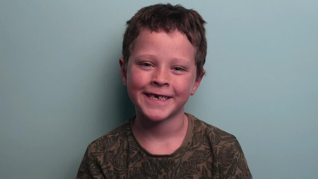 child shows his baby teeth. he is missing a tooth.