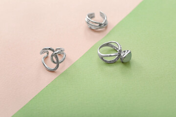Silver rings on color background