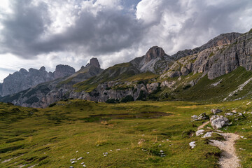 Fototapeta na wymiar Stunning mountain views. Picturesque landscape. The mountains are covered with dense green forest. Tourist trails. Dark clouds. Beautiful mountain landscape. Dolomites. Italy.