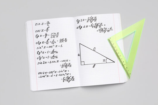 Copybook with maths formulas and ruler on grey background - Powered by Adobe