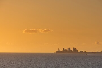 Fototapeta premium Orange sunset over the sea during summer in Maspalomas, Gran Canaria, Spain
