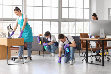 Young janitors cleaning in office