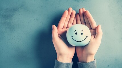 Holding a head with a happy smiling face in the hands, mental health concept, positive thinking,...