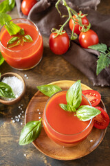 Glasses of fresh tomato juice  with tomatoes, salt on wooden table. Vegetable tomato drink for a healthy diet.