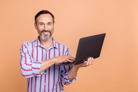 Photo of cheerful successful lawyer hold wireless netbook communicate email microsoft apple twitter facebook isolated on beige color background