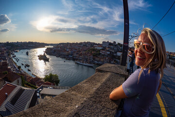 Porto, Portugal - Female traveller enjoying the stunning sunset above the Douro river in Porto...