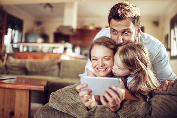 Young family taking a selfie on the couch in the living room