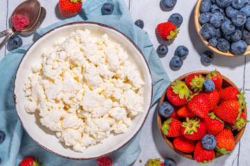 Cottage cheese with berries. Bowl of cottage cheese with strawberry, blueberry, high-protein summer healthy breakfast or lunch, copy space