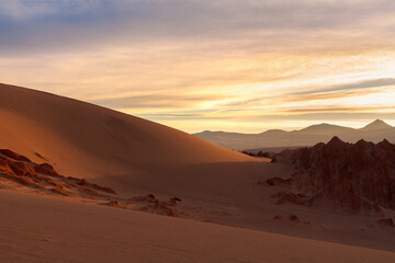 Fototapeta na wymiar Sunrise illuminating the salt formations and sand dunes at Valle de la Muerte near San Pedro de Atacama in the Atacama desert, Chile
