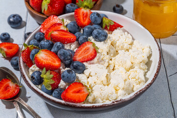 Cottage cheese with berries. Bowl of cottage cheese with strawberry, blueberry, high-protein summer healthy breakfast or lunch, copy space