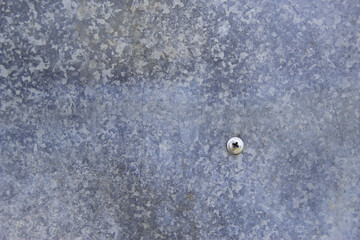 grey metal background with a screw