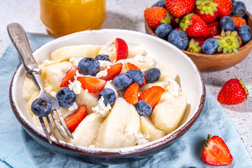 Homemade cottage cheese boiled gnocchi with berries, lazy dumplings vareniki with fresh strawberry and blueberry 