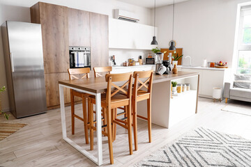 Interior of light kitchen with modern appliances on wooden table