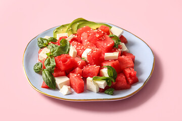 Plate of tasty watermelon salad on pink background