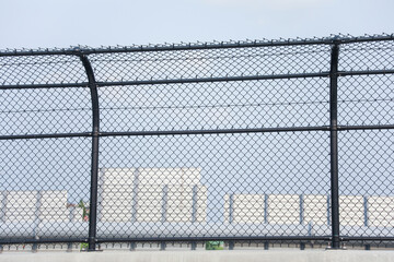 Chain-link fence symbolizes boundaries, security and isolation. Metaphor for protection and confinement. Concept of division and connection