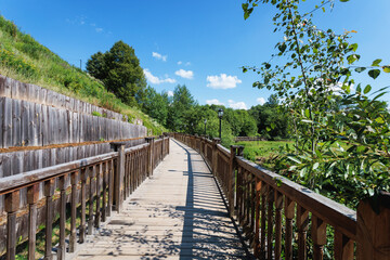 Obraz premium Wooden bridge over the river in the park on a summer day