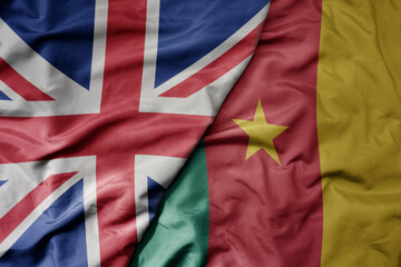big waving national colorful flag of great britain and national flag of cameroon .